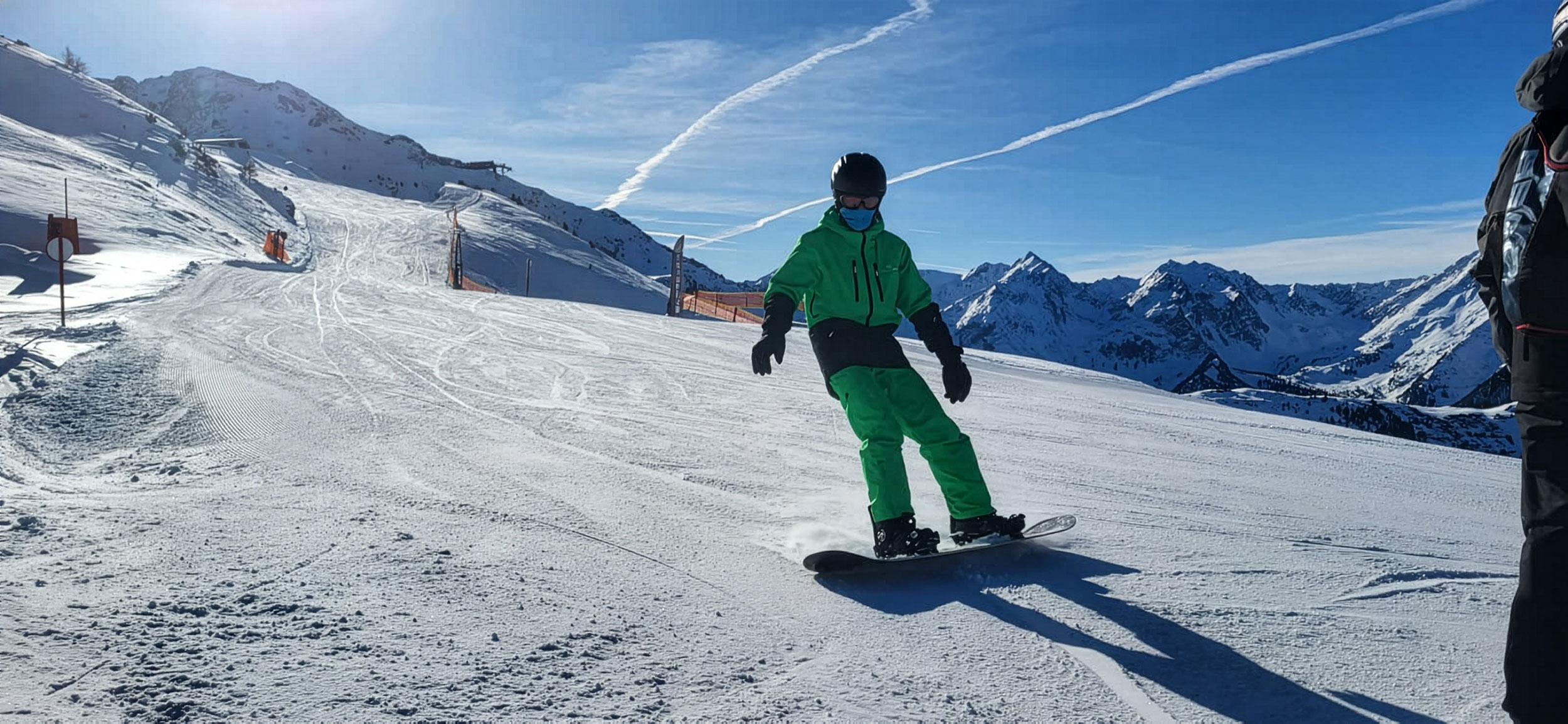 Skifahrer am Hang vor blauem Himmel
